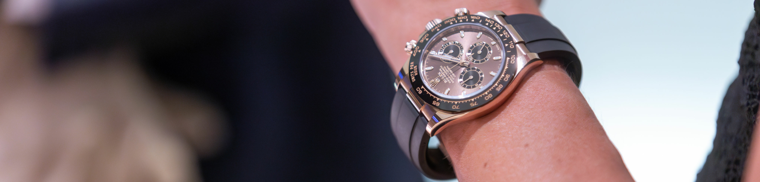 The wrist of a woman with a watch on it.