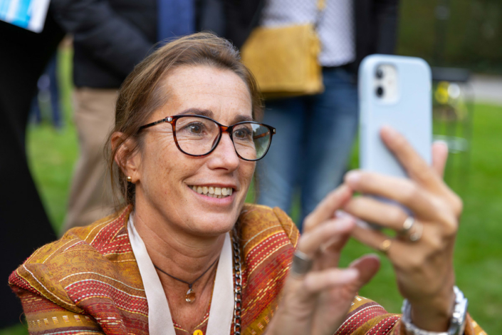 A woman takes a selfie with a cell phone.