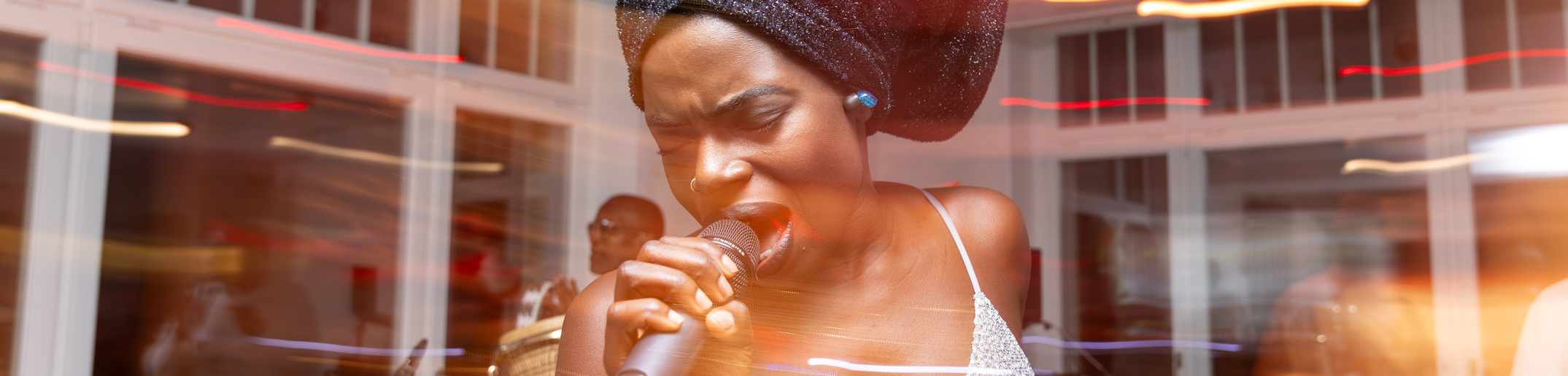 A woman sings into a microphone.